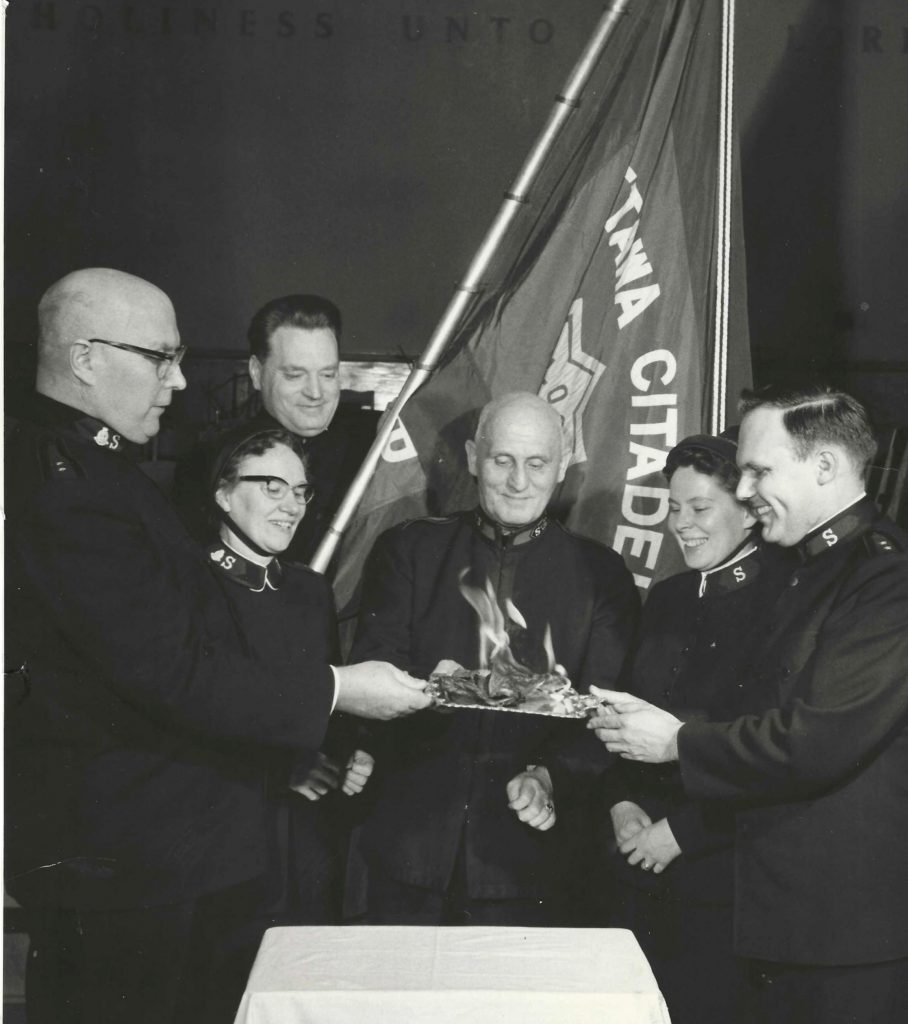 A group of people burn a piece of paper.