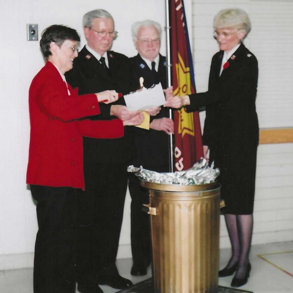 A group of people burn a piece of paper.