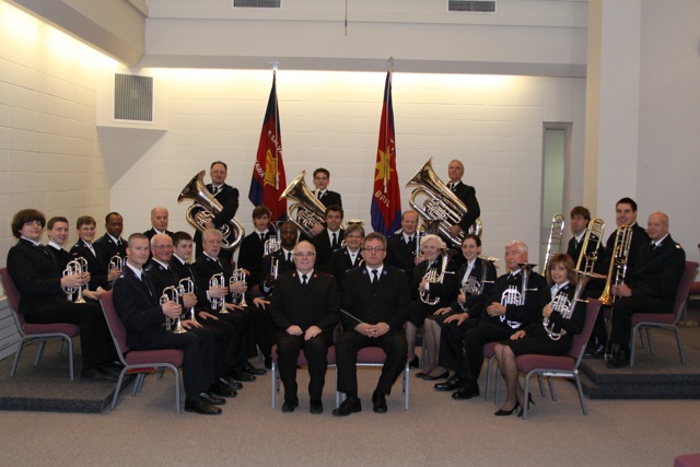 Musicians with brass instruments pose in the sanctuary