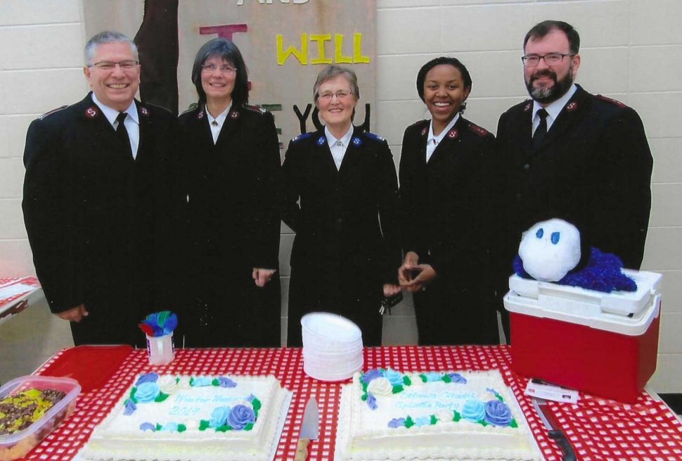 A group of officers pose for a photo with a snowball mascot.